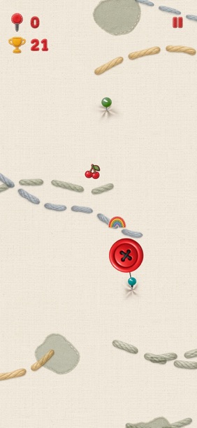 Last Button gameplay with a red button circling a turquoise sewing pin, a green pin ahead, stitched paths, fabric patches, cherries, and a rainbow.
